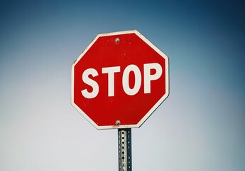 A red stop sign with the word "STOP" written in white on it, standing against a plain background.
