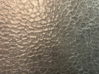 Close up detailed texture of rippled textured glass. Also called aquatex or spraylite glass, seamless background texture