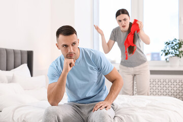 Obraz premium Puzzled wife finding mistress bra and unfaithful husband in bedroom, selective focus