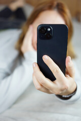 Red-haired girl talking on phone in bed