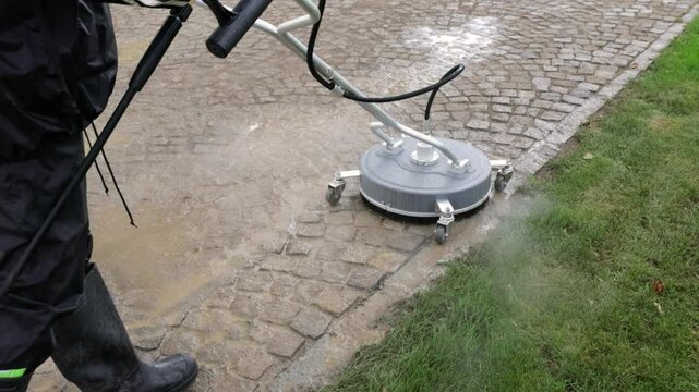Cleaning service worker washes dirty cobblestone