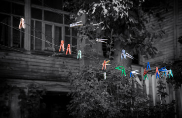Life in the slums. Dilapidated housing. Multicolored clothespins on clotheslines against the background of a house.