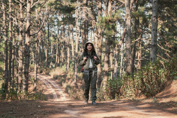 Obraz premium Travelers hiking through a forest with backpacks, exploring the wilderness and taking in the sights of nature as they walk.