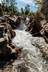 Fototapeta premium A waterfall is flowing down a rocky cliff
