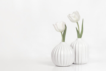 Two white textured vases with pair of tulip flowers