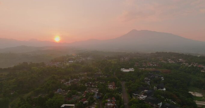 Aerial drone shot of the sun rising over the mountains in Bogor, Indonesia