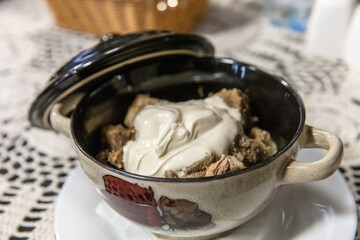 A bowl of food with a white sauce on top