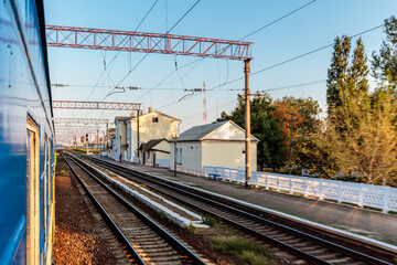 Fototapeta premium A train is traveling down the tracks with a blue and white train car