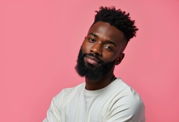 Obraz premium A young Black man with a beard and a white shirt looks directly at the camera.