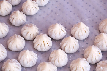 Woman making sweet rice modak stuffed with grated coconut and jaggery, Steamed or ukdiche Modak. It's a traditional sweet dish made out of coconut, jaggery