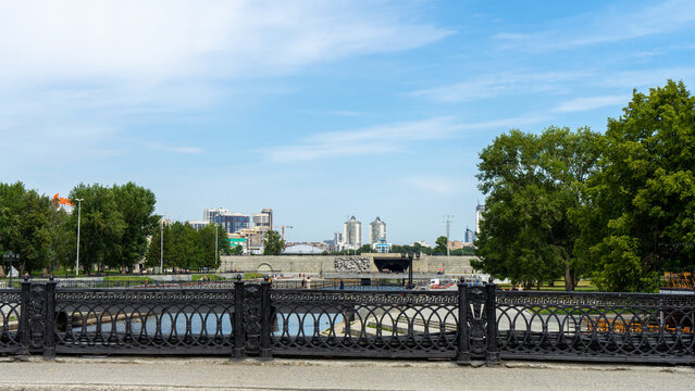 Dam of city pond on river Iset is hydraulic engineering structure in Yekaterinburg. Walking along embankment of Iset River in Yekaterinburg, Russia on summer day