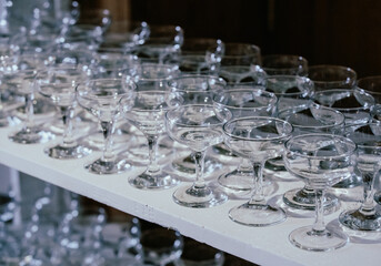 shelf filled with empty champagne glass with wide opening indoor during an event