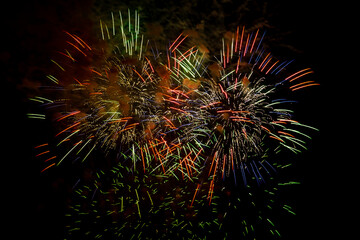 Multicolored figures bright sparks fireworks on the black sky