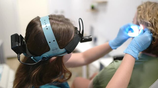 A patient is seen by an otolaryngologist. A professional ENT doctor examines a patient. An otolaryngologist examines a patient's inner ear using an otoscope