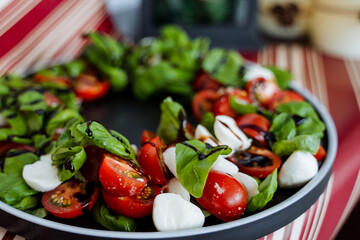 A truly delicious salad crafted with ripe, fresh tomatoes, creamy mozzarella cheese, and aromatic basil, all elegantly arranged on a beautiful plate to provide a delightful meal experience