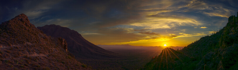 Breathtaking panoramic view of a vibrant sunset over desert mountains, showcasing natural beauty and tranquility in warm tones.