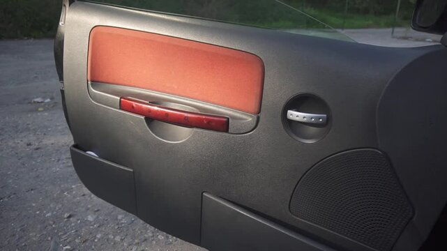 Black car door trim with red trim panel and red door handle