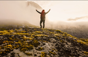 An Adventurous Hiker Is Embracing the Splendor of Nature While on a Misty Mountain Trail