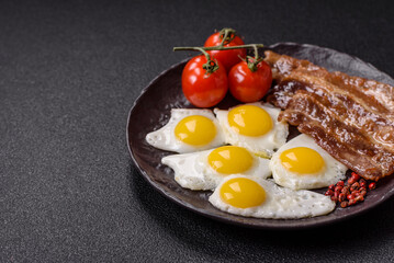 A hearty, delicious breakfast with fried eggs, bacon and tomatoes