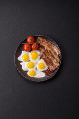 A hearty, delicious breakfast with fried eggs, bacon and tomatoes