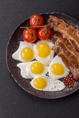 A hearty, delicious breakfast with fried eggs, bacon and tomatoes