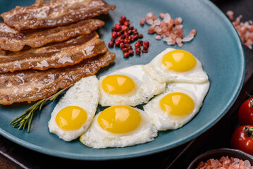 A hearty, delicious breakfast with fried eggs, bacon and tomatoes