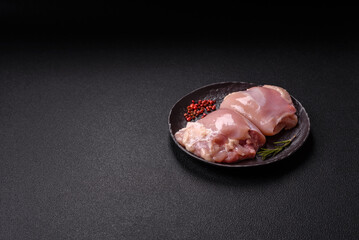 Fresh raw chicken thigh fillets with salt, spices and herbs