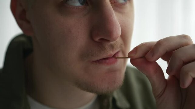 Oral hygiene with a toothpick.
A person uses a toothpick to remove leftover food from his mouth.
Wooden toothpick