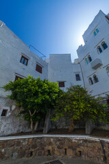traditional whitewashed building with a charming balcony, nestled amidst a maze of narrow streets and steps, offering a glimpse into the authentic character of a historic Mediterranean city