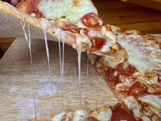 slice of pizza with melting melting cheese