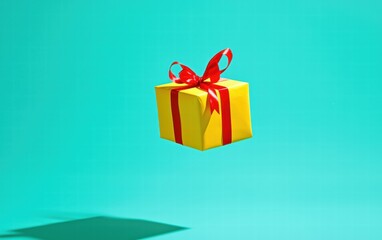 Obraz premium A bright yellow present with a red ribbon levitating on a vivid turquoise background