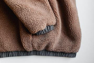 Color of the Year 2025 Mocha Mousse color. Chocolate or Brown Background. Close-Up of a Brown Fleece Jacket With Textured Fabric and Elastic Cuffs