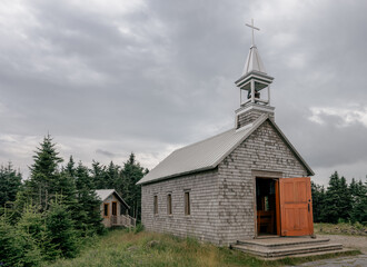 side angle view of a small wooden church on top of a mountain in summer