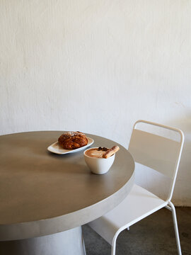Cup of cappuccino and pastry served at a table