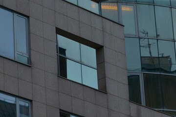 This is a detailed view of a building facade that showcases modern glass windows accompanied by structural elements