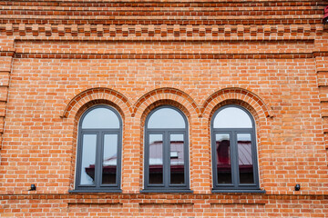 The solid brick building prominently features three beautifully crafted arched windows, which add...