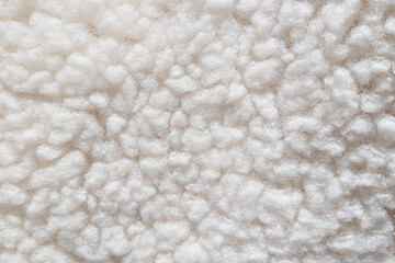 Close-up of soft white fleece texture with a cozy and fluffy appearance. 