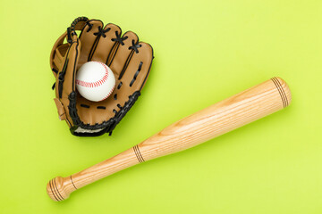 Baseball glove and bat with ball on color background, top view