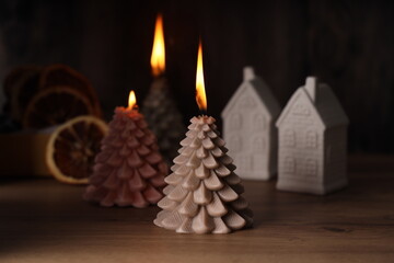 A cozy, beautifully candlelit scene featuring decorative Christmas trees and charming houses