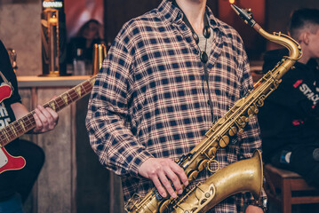 Man play wind instrument, musician saxophone performs concert in nightclub bar