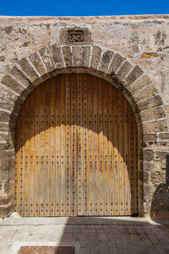 weathered wooden door with an arched stone frame and a keystone marked "1243", creating a visually striking and historically evocative entrance