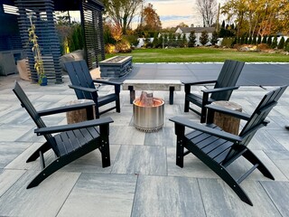 Outdoor sitting area fire pit in a chilly New York backyard in the fall. Enjoy landscaping, foliage and beauty while staying warm and cozy. Perfect for solo, friends and family entertaining outside.