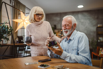 senior wife bring husband coffee while he repair electronic device