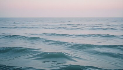 Océano azul tranquilo con olas ondulantes bajo un cielo brumoso

