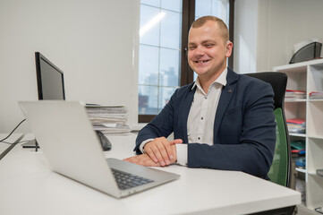 Caucasian deaf man talking sign language over video call on laptop in office.
