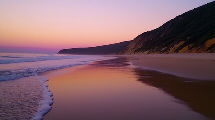 Fototapeta premium Serene sunset reflecting on a tranquil beach with gentle waves and cliffs.
