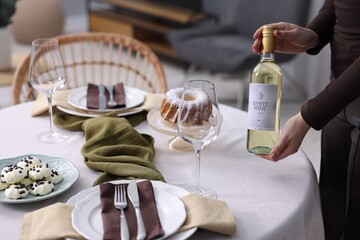 Woman setting table for dinner at home, closeup