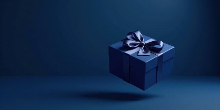 A luxuriously wrapped present, a deep blue box adorned with a matching satin ribbon, floats serenely against a monochromatic backdrop