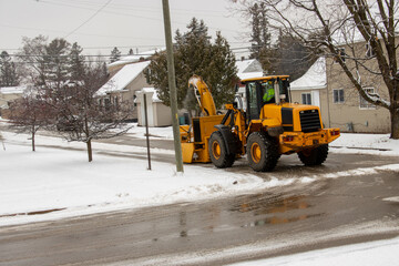 excavator on the road removing snow