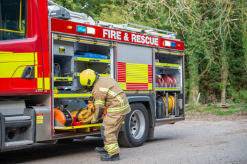 Emergency firefighter taking equipment from a fire engine